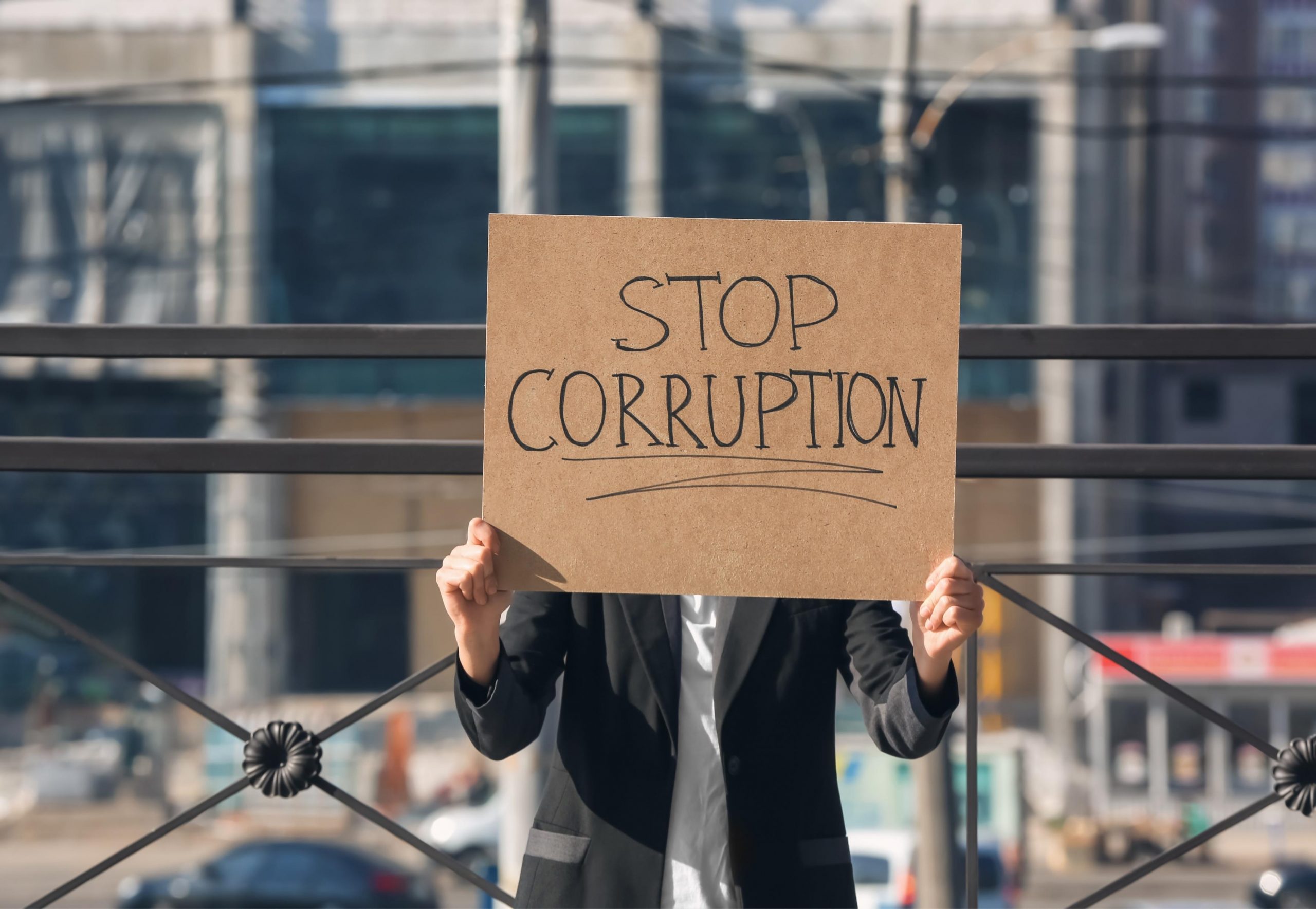 Person holding sign that says 'Stop Corruption'